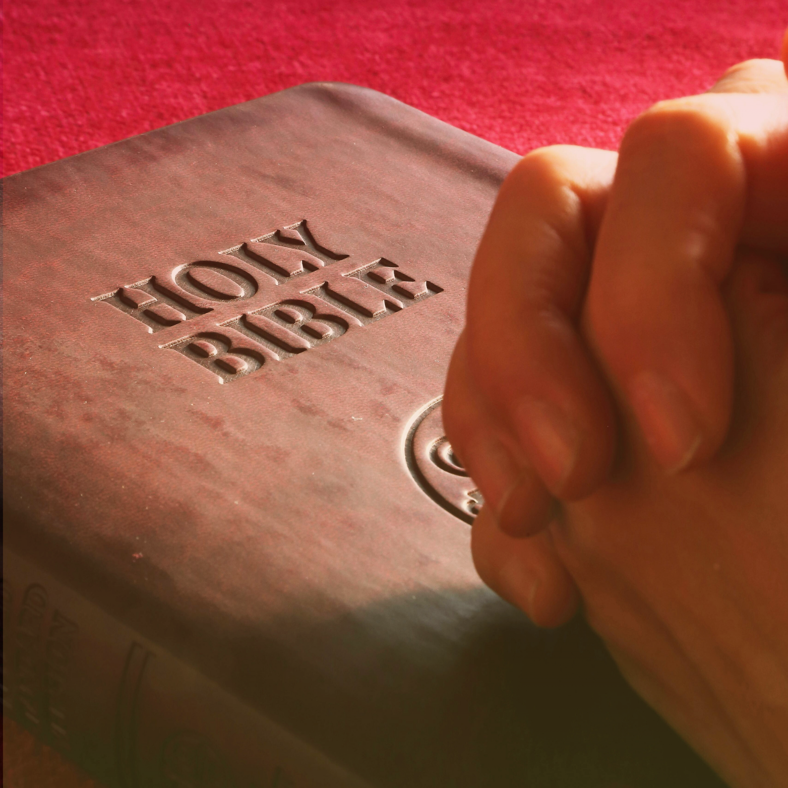 Bible with praying hands